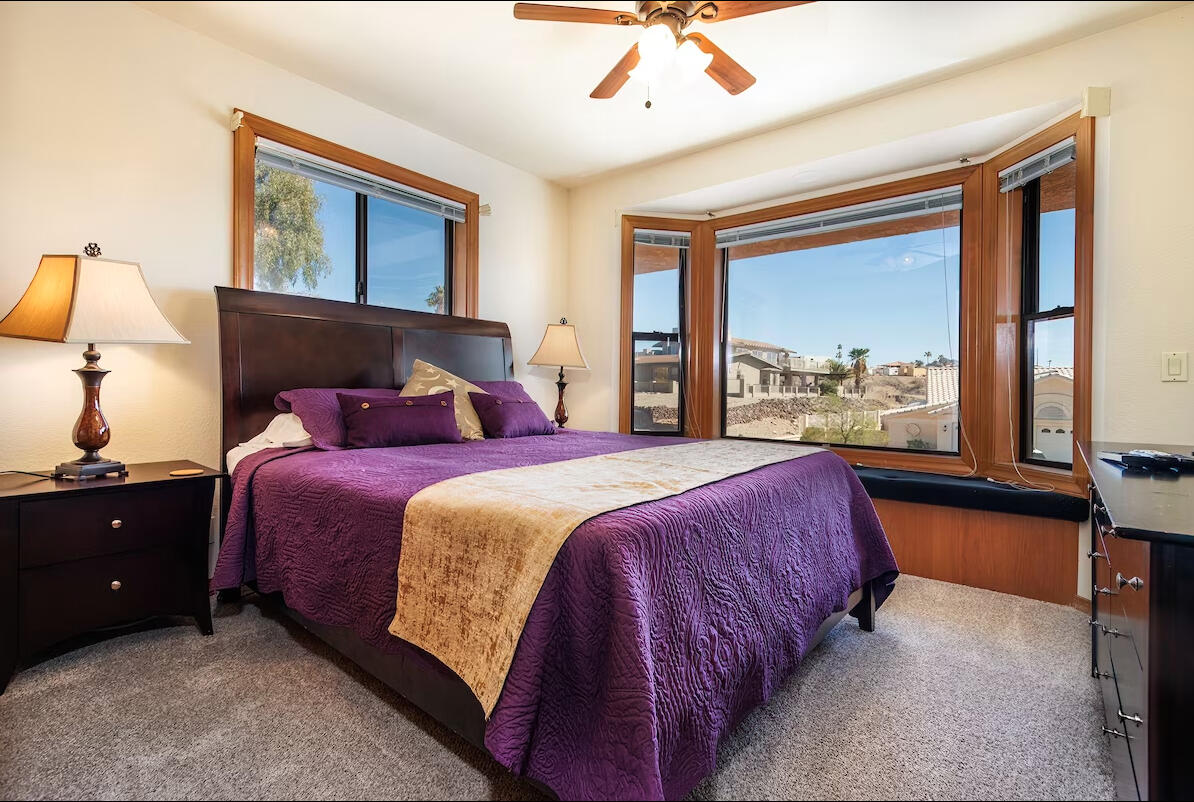 Comfortable guest bedroom at Lakeview Lodge vacation rental in Lake Havasu City Arizona with queen bed, large bay window and neighborhood views